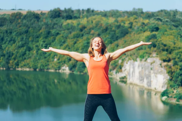 Genç kadın uzanmış kolları olan güneşli Park