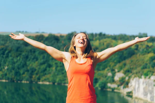 Young Woman in sunny park with outstretched arms — Stock Photo, Image