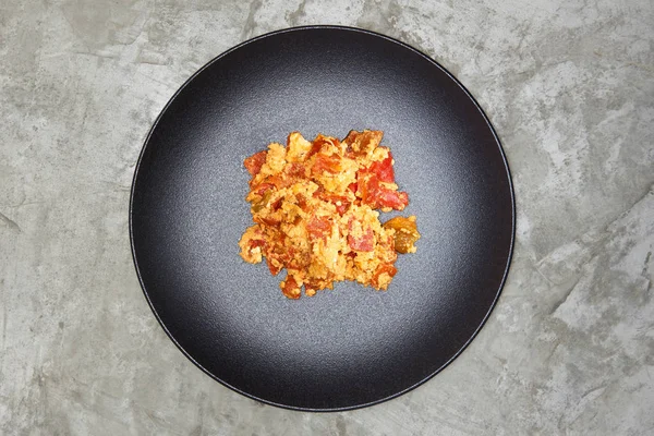 Tortilla con pimientos rojos en plato negro sobre fondo vintage —  Fotos de Stock