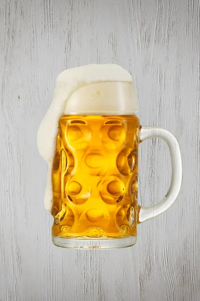 Брызги пива в стекле на винтажном фоне с копировальным пространством — стоковое фото