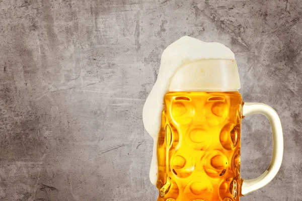 Брызги пива в стекле на винтажном фоне с копировальным пространством — стоковое фото