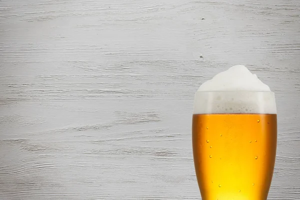 Beer splash in glass on vintage background with copy space — Stock Photo, Image