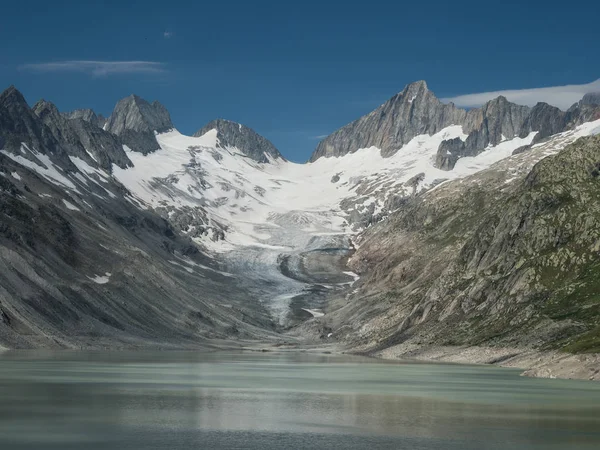 Альпийская долина с озером, ледником и острыми вершинами — стоковое фото