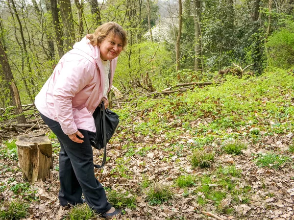 Mature woman resting on a stump in the Park — Stock Photo, Image