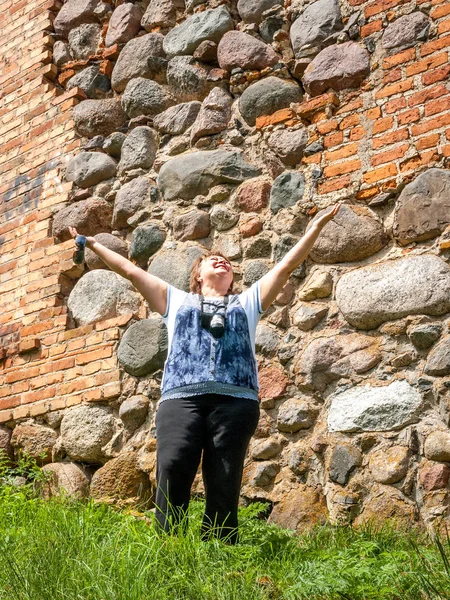Madura regordeta mujer inspecciona un antiguo castillo . —  Fotos de Stock