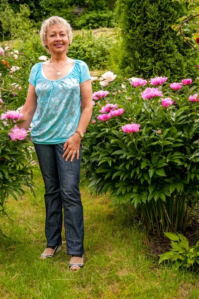 Mujer madura en Park sonriendo y mirando a la cámara — Foto de Stock