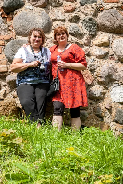 Två mogna fylliga kvinnliga turister inspektera ett gammalt slott på th — Stockfoto