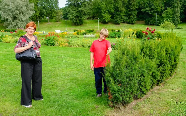 Moeder en zoon wandelen in het stadspark. — Stockfoto