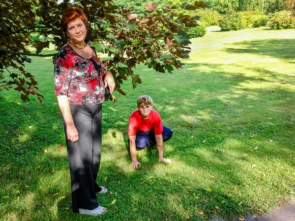 Mutter und Sohn spazieren im Stadtpark. — Stockfoto
