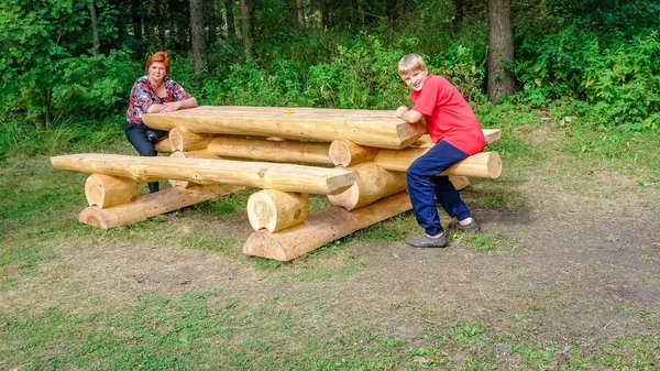 Mutter und Sohn beim Spaziergang im Stadtpark. sitzt an einem Tisch von l — Stockfoto