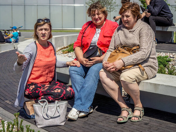 A group of Mature tourists relax on a bench in a city Park