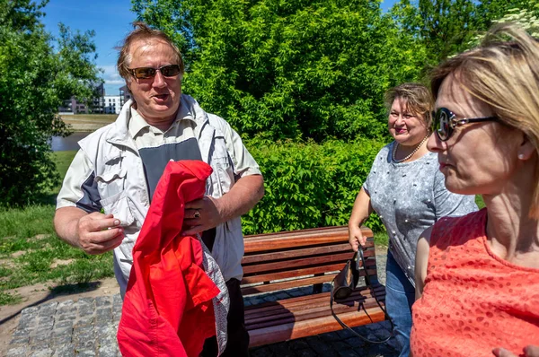 A group of Mature tourists relax on a bench in a city Park — Stock Photo, Image