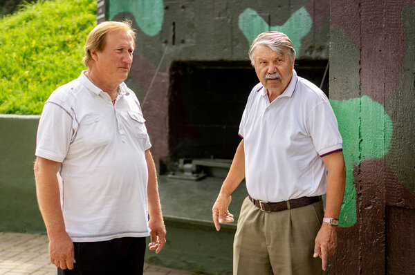 Mature men, tourists, on a tour of the military Museum on a Sunn