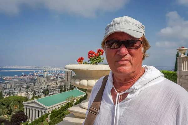 Brooding Homme mûr en lunettes de soleil et casquette marche dans le parc — Photo