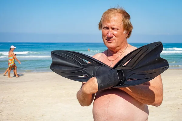 Mature man with flippers going swimming — Stock Photo, Image