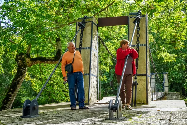 Les touristes matures marchent et prennent des photos dans le parc au bord de l'eau — Photo