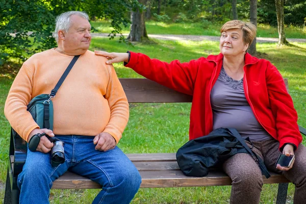 Reife Touristen spazieren und fotografieren im Park am Wasser — Stockfoto