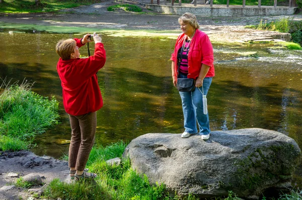 Mature plump women in red relax and take pictures in the city Pa — Stock Photo, Image