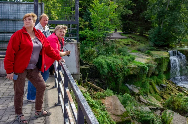 En grupp mogna turister koppla av och ta bilder i staden P — Stockfoto