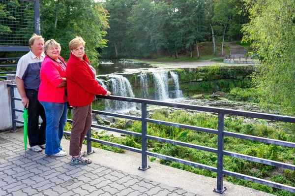 En grupp mogna turister promenader och tar bilder i staden — Stockfoto