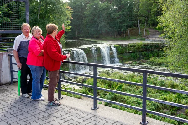 En grupp mogna turister promenader och tar bilder i staden — Stockfoto