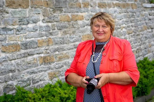 Une femme mûre et dodue marche dans un ancien château, sourit et regarde — Photo