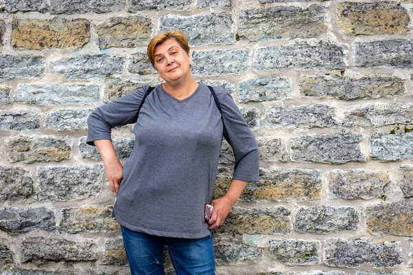 A Mature plump woman walks in an ancient castle, smiles and look — Stock Photo, Image