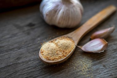 Birkaç sarımsak soğanı ve karanfil, ahşap bir masanın üzerinde.