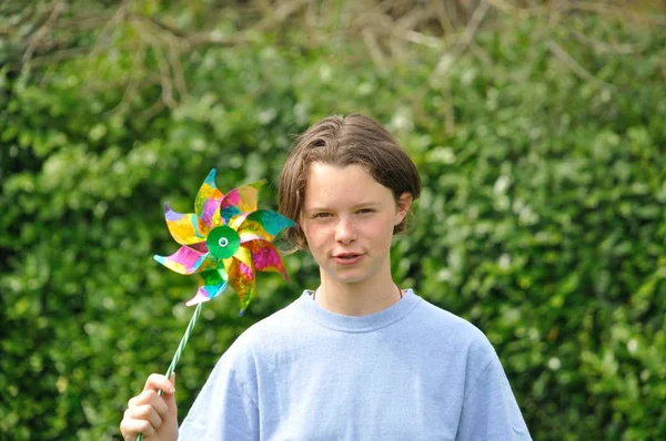 Porträtt av ung flicka med färgade pinwheel — Stockfoto