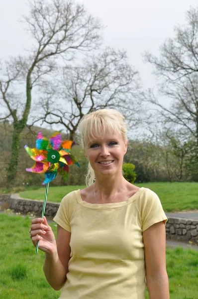A blond woman with coloured pinwheel — Stock Photo, Image