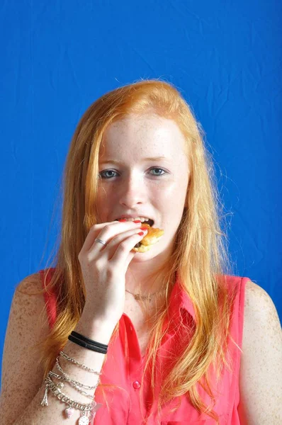 Un adolescente comiendo un bollo de chocolate —  Fotos de Stock
