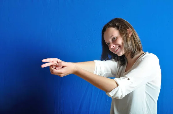 10 代の少女が銃を保持してのジェスチャーを miming — ストック写真