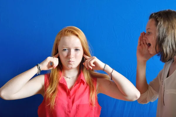 Two teen, one shouting the other plug her ears — Stock Photo, Image