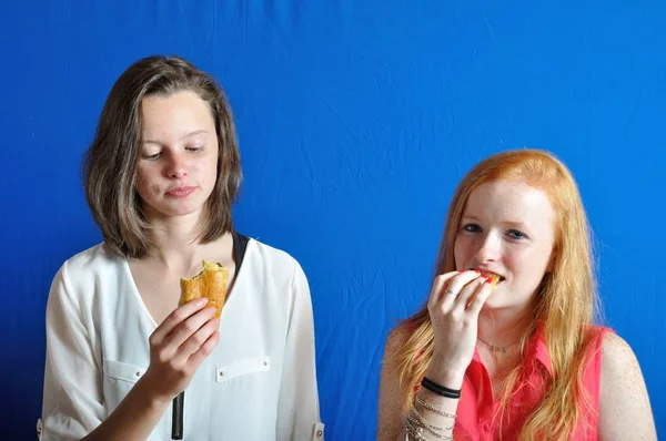 Dos adolescentes comiendo un bollo de chocolate — Foto de Stock