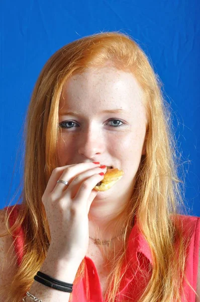A  teen eating a chocolat bun — Stock Photo, Image