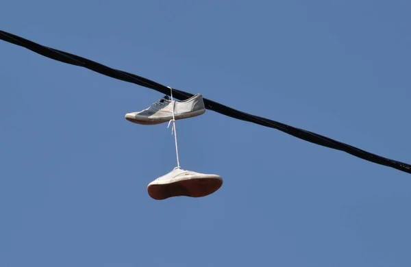 Shoes tied onto a powerline — 스톡 사진