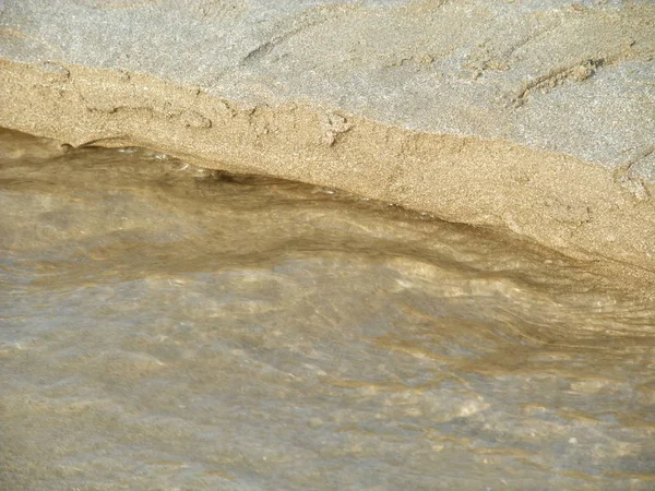 Acqua che scorre sopra sabbia formando modello — Foto Stock