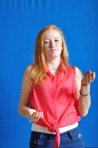 Tiener spreken met haar handen op blauwe achtergrond — Stockfoto