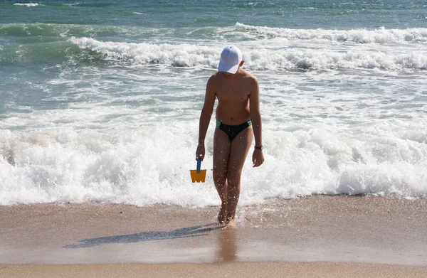 Der Typ ein Teenager vor blauem Himmel bei klarem Wetter ist am Ufer. — Stockfoto