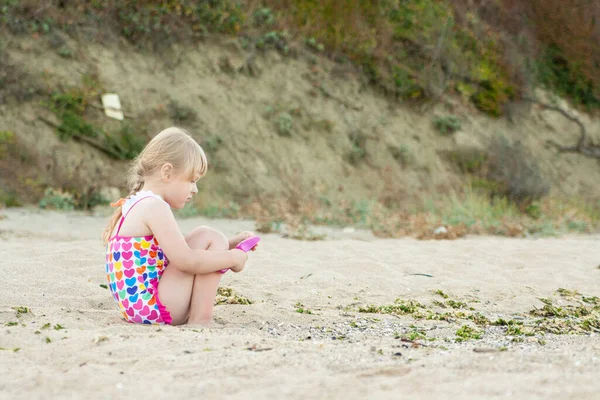 C hild jugando con arena en la playa en verano . — Foto de Stock