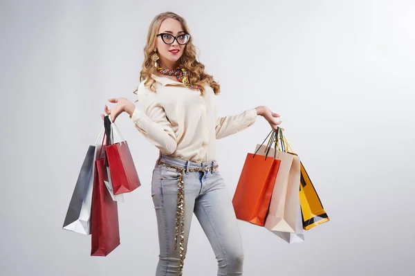 Mujer sosteniendo bolsas de compras sobre un fondo blanco — Foto de Stock
