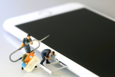 Minyatür işçiler bir akıllı telefon SIM kartı takma