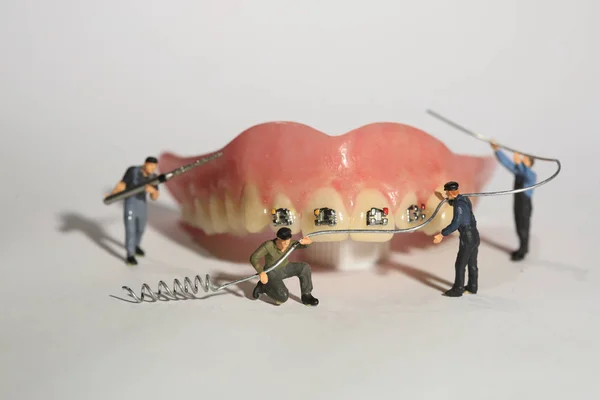 Miniatuur werknemers tandheelkundige ingrepen uitvoeren. Dental Office Ar — Stockfoto