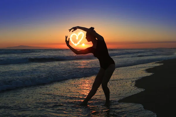 Jovem dançarina habilidosa na praia durante o pôr do sol — Fotografia de Stock