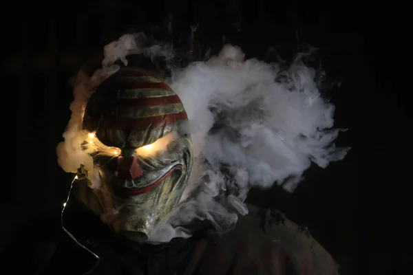 Hombre usando una máscara con humo y luces — Foto de Stock