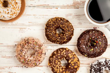 Tasty donuts on white wood background clipart