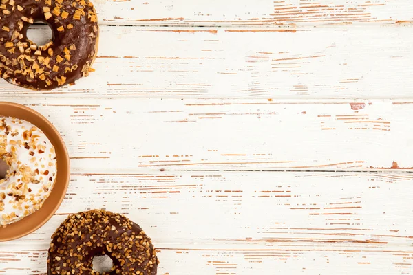 Leckere Donuts auf weißem Holz Hintergrund — Stockfoto