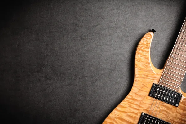 Guitarra eléctrica sobre fondo de cuero oscuro — Foto de Stock