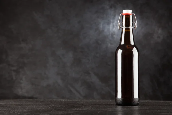 暗めの背景にビール瓶 — ストック写真