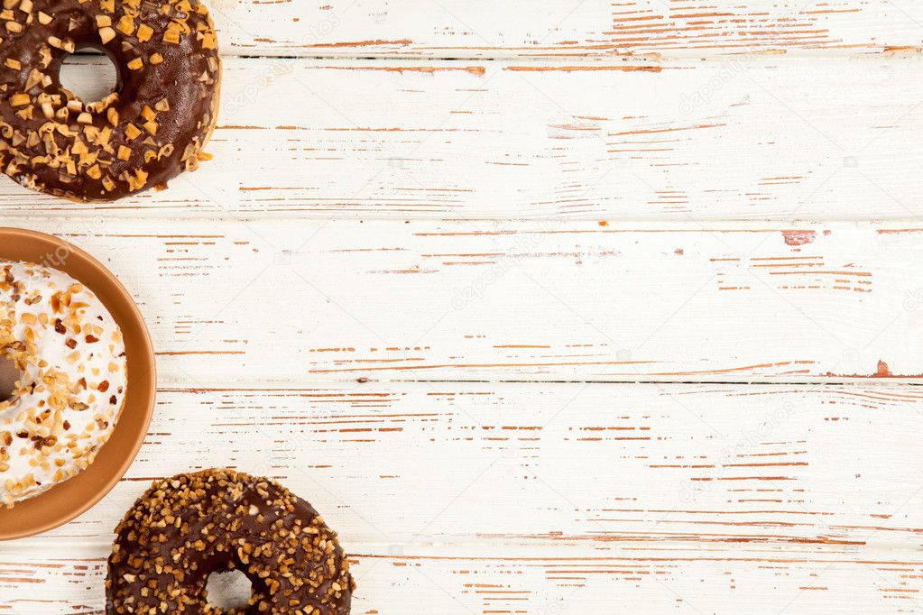Tasty donuts on white wood background